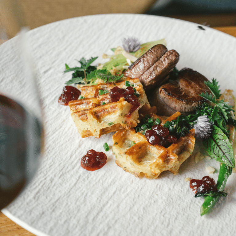 Rehmedaillons Gericht. Das FLeisch stammt aus eigener Jagd. Es ist noch ein Rotwein Glas zu sehen.