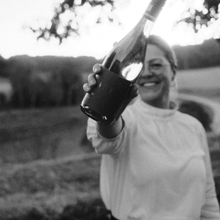 Anja Winter mit einer Flasche Rose in der Hand.