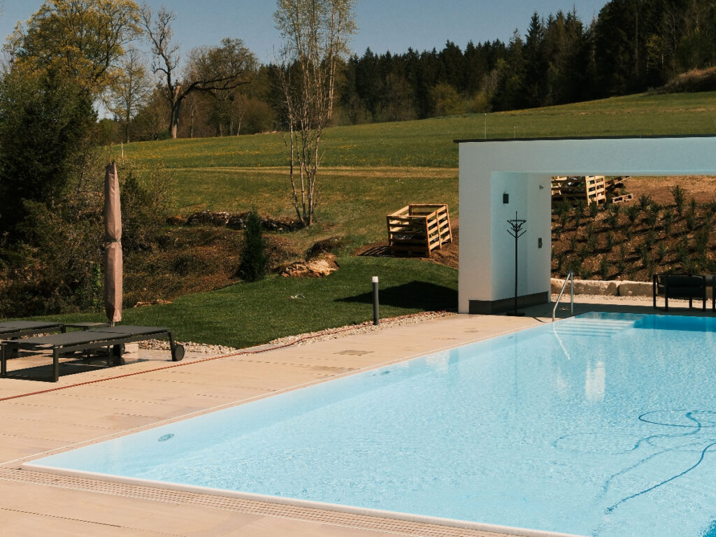 Frischer Rollrasen am Pool des Restaurant und Landhotel Winter mit heimattypischen Pflanzen und einem weiten Blick in die Natur.