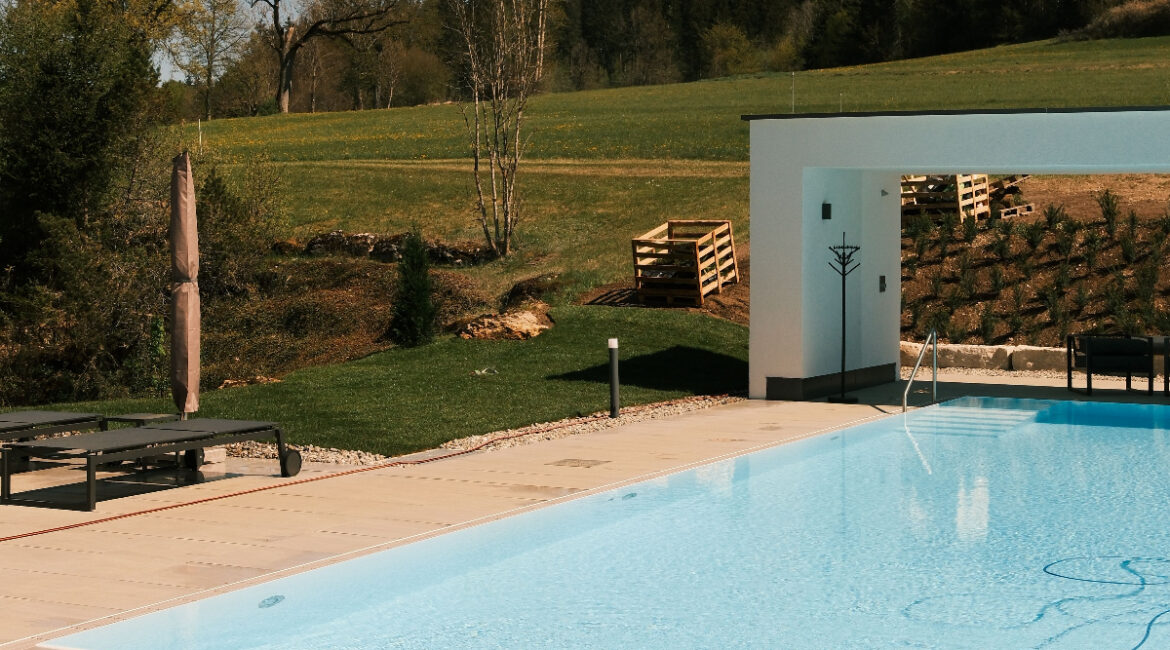 Frischer Rollrasen am Pool des Restaurant und Landhotel Winter mit heimattypischen Pflanzen und einem weiten Blick in die Natur.